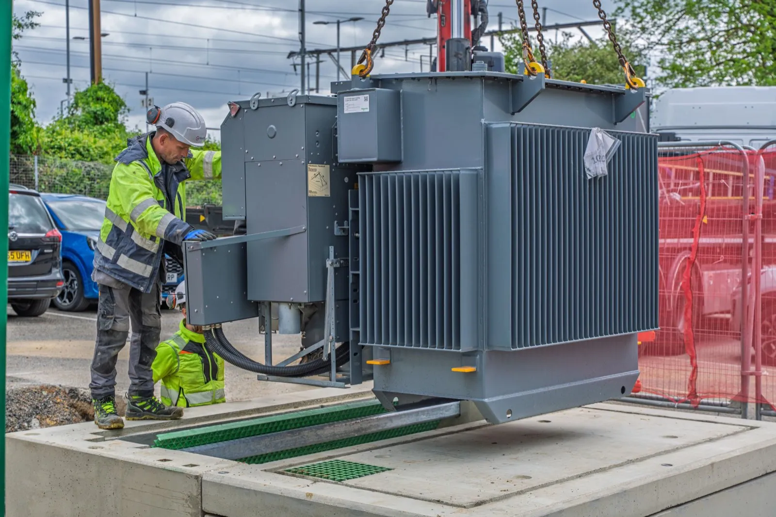 Engineers lowering a transformer into a new substation base